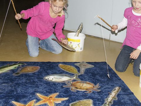 Twee meisjes hengelen naar houten vissen