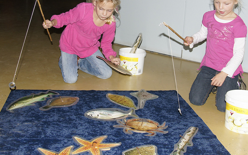 Twee meisjes hengelen naar houten vissen