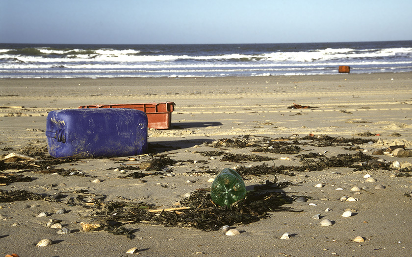 Zwerfvuil in het vloedmerk op strand